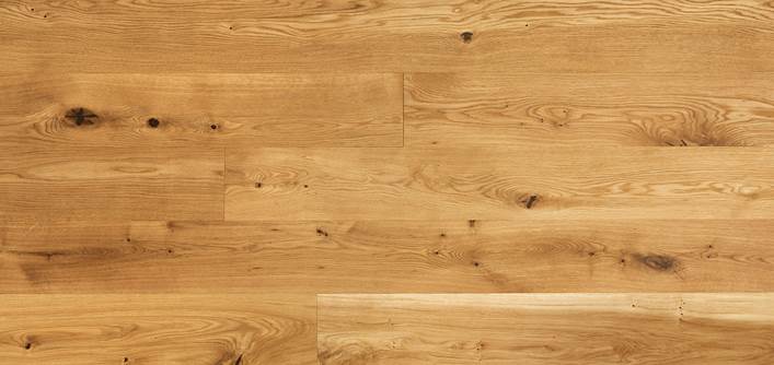 Plancher en bois « image » brun clair avec des motifs de grain visibles et des nœuds, disposés en planches horizontales.
