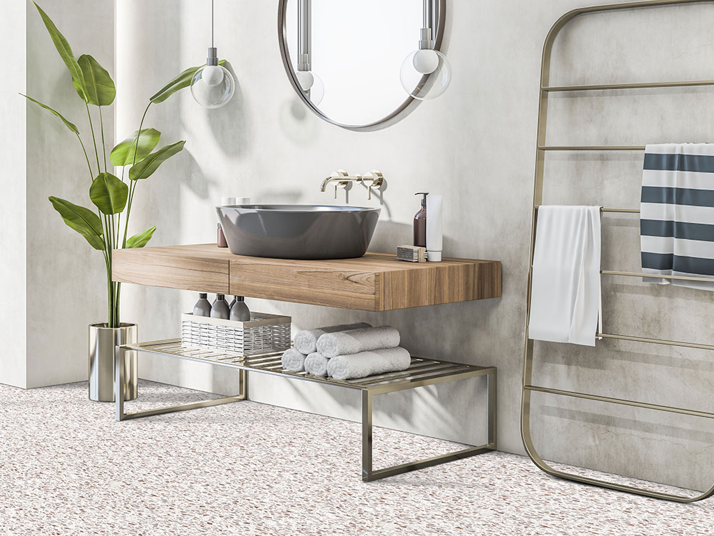 Modern bathroom featuring the Alabaster-Terazzo-web floating wooden vanity, vessel sink, round mirror, towel racks, potted plant, and neatly arranged towels and toiletries.